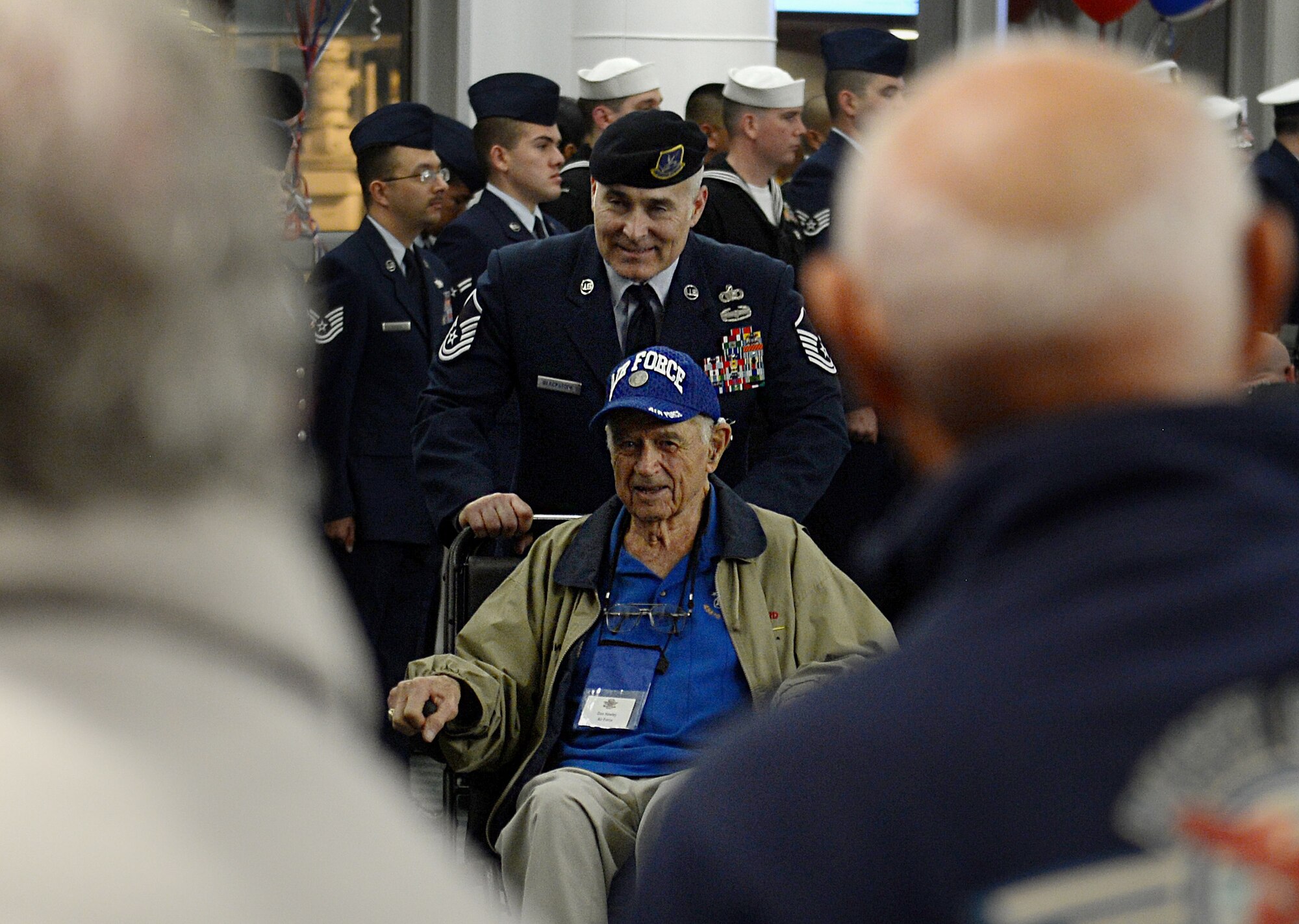 Master Sgt. Richard Blackstone, 627th Security Forces Squadron operations superintendent, escorts a Veteran to the SeaTac atrium during the United Services Organizations Honor Flight event April 25, 2016 at the SeaTac International Airport, Wash. Service members greeted the Veterans as they stepped off the airplane from visiting the WWII Memorial in Washington, D.C. They thanked them for their service to our country and escorted them down to the SeaTac atrium where they were applauded for their service by more than 500 family, friends and bystanders. (U.S. Air Force photo/Senior Airman Divine Cox)