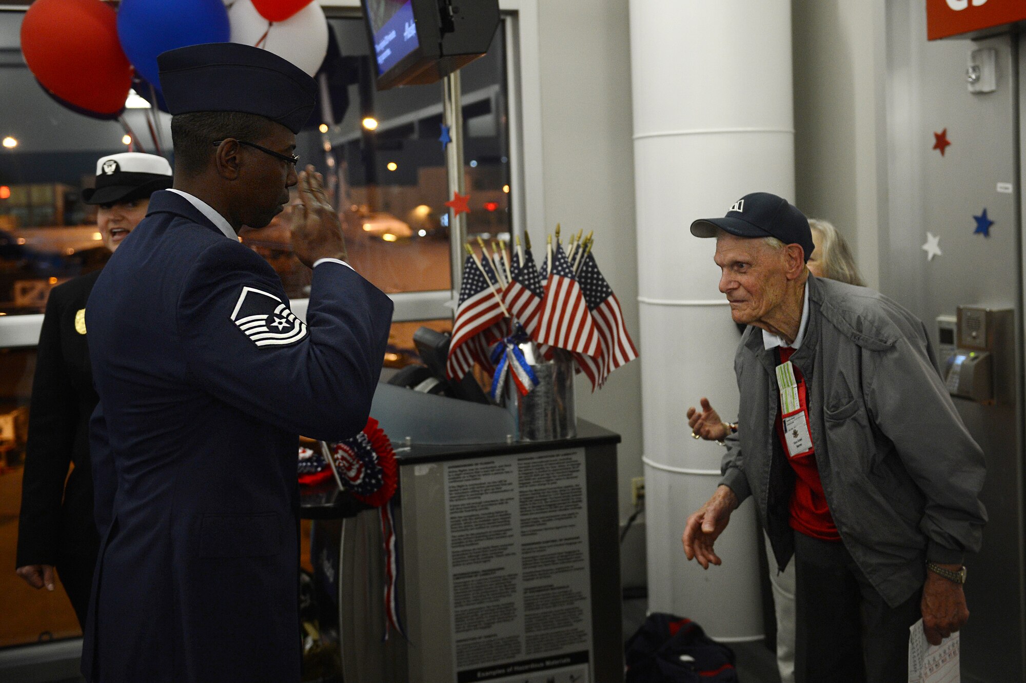 Master Sgt. Harvey Gilchrist, 627th Force Support Squadron sports and fitness section chief, salutes a World War II Veteran during the United Services Organizations Honor Flight event April 25, 2016 at the SeaTac International Airport, Wash. More than 20 Airmen from Team McChord volunteered their time to greet and escort the WWII Veterans upon their arrival. (U.S. Air Force photo/Senior Airman Divine Cox)