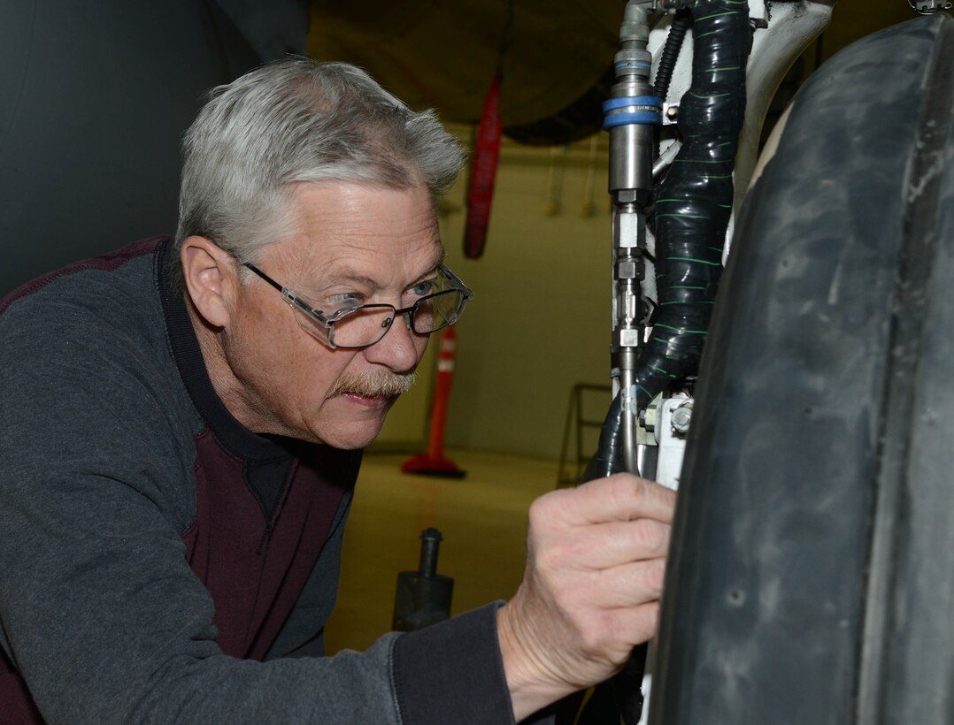 Steven Popolizio, a model maker with the 412th Instrumentation Division, applies temperature sensor tabs to the main landing gear of an F-15D Eagle. The sensors are part of the F-15 Wheel and Brakes System Improvement tests. (U.S. Air Force photo by Christopher Ball)