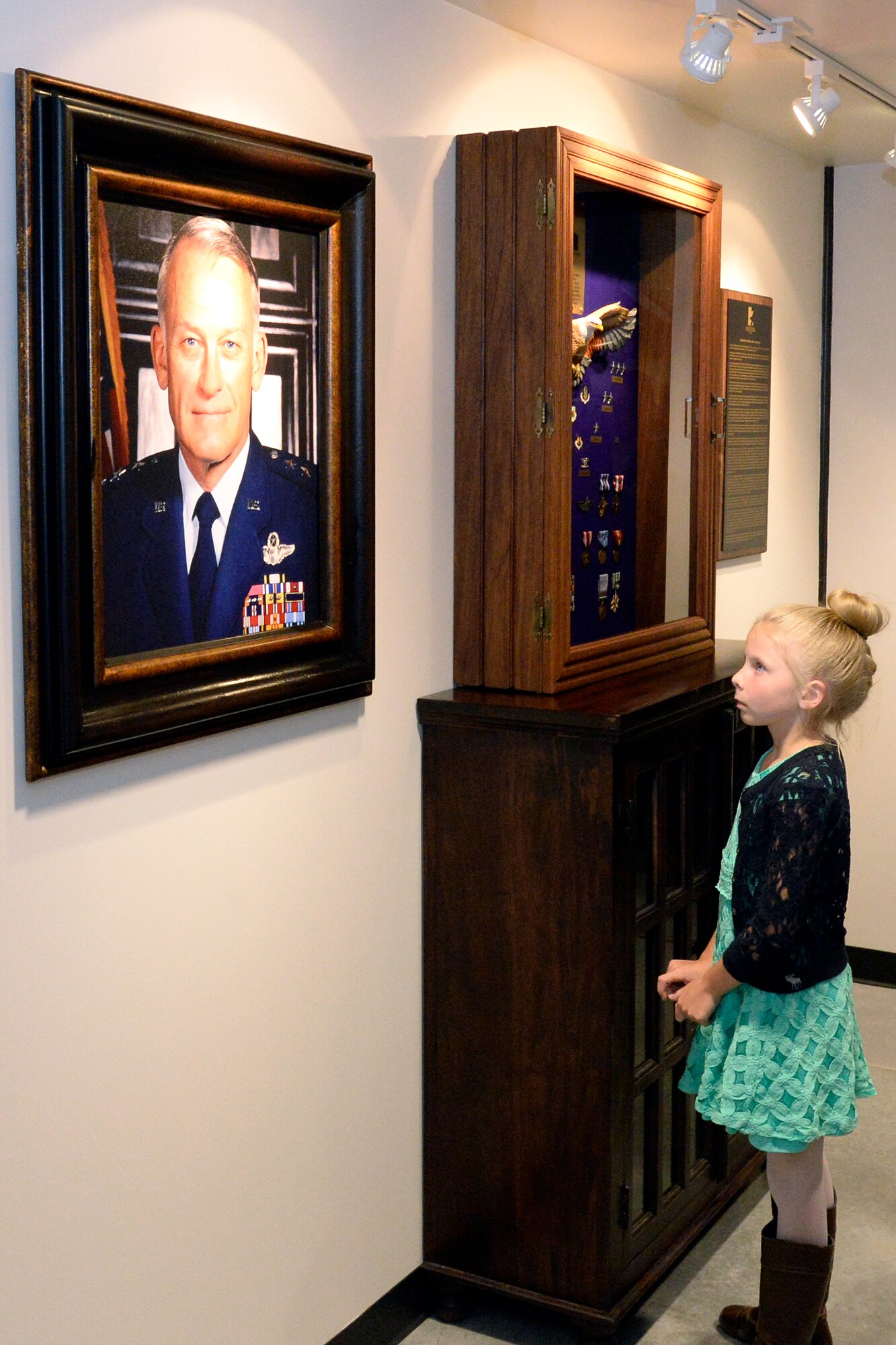 Faeya Chatlin admires a photo of her late great-grandfather Lt. Gen. Marc C. Reynolds, at the newly opened Lieutenant General Marc C. Reynolds Aerospace Center for Education at Hill Air Force Base, April 27, 2016. The Reynolds Aerospace Center for Education, located at the Hill Aerospace Museum, is partnering with local school districts providing additional co-curricular educational opportunities with elementary aged school children. Starting in the fall of 2016, additional children will visit the Hill Aerospace Museum and participate in hands-on activities that correspond directly with the Science curriculum of their particular grade. (U.S. Air Force photo by Todd Cromar)