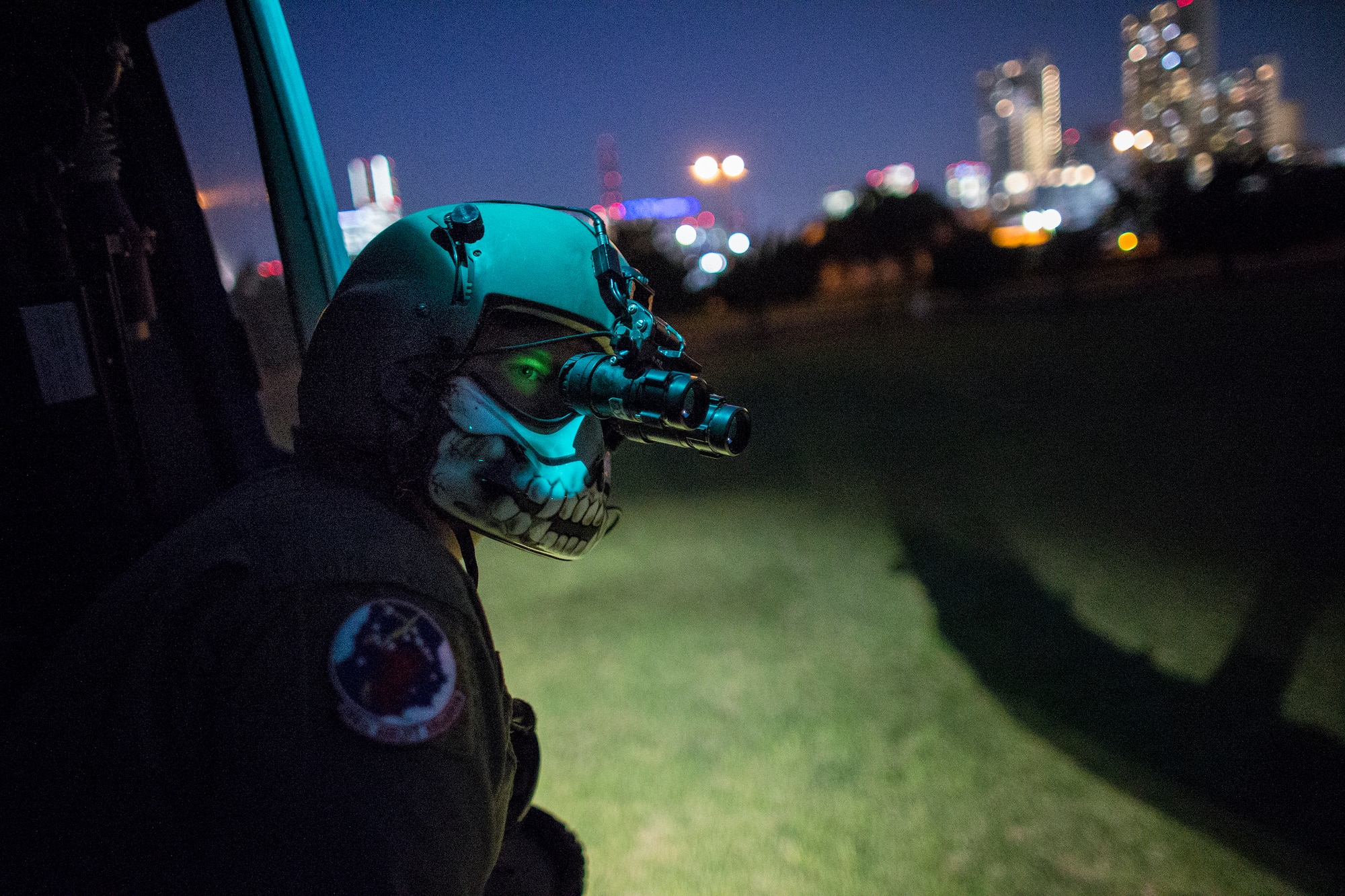 Tech. Sgt. Christopher Rector, 459th Airlift Squadron UH-1N Iroquois special missions aviator evaluator, performs a visual conformation using night vision goggle during a training flight over U.S. Army Garrison Yokohama North Dock, April 25, 2016. The 459 AS frequently trains on a multitude of scenarios in order to stay prepared for potential real-world contingencies and operations. (U.S. Air Force photo by Yasuo Osakabe/Released)