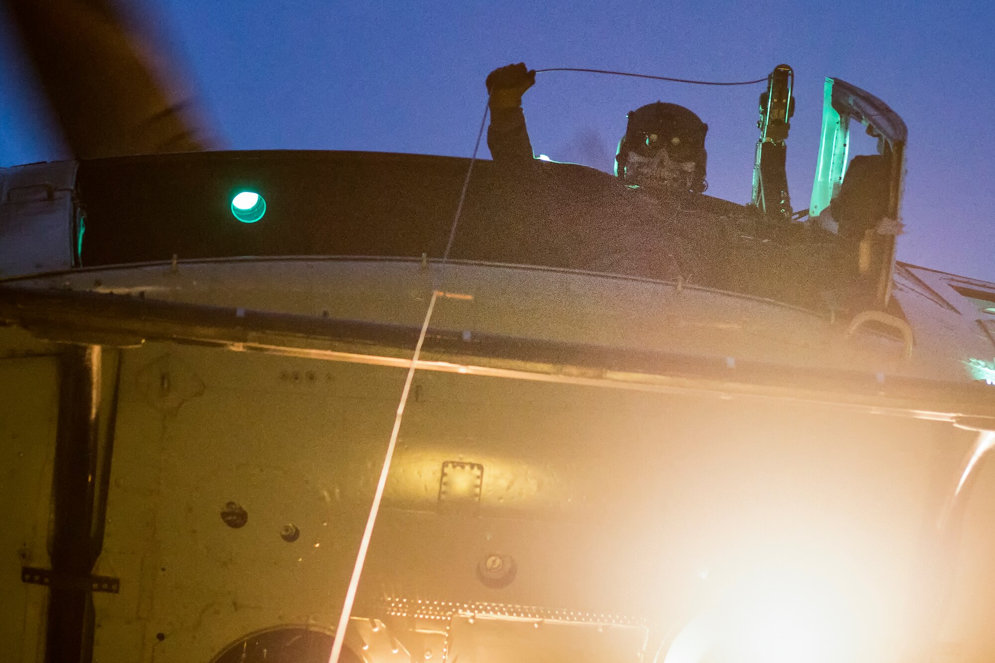 Tech. Sgt. Christopher Rector, 459th Airlift Squadron UH-1N Iroquois special missions aviator evaluator, raises a hoist while using night vision goggle during a night training flight over U.S. Army Garrison Yokohama North Dock, April 25, 2016. The 459 AS frequently trains on a multitude of scenarios in order to stay prepared for potential real-world contingencies and operations. (U.S. Air Force photo by Yasuo Osakabe/Released)