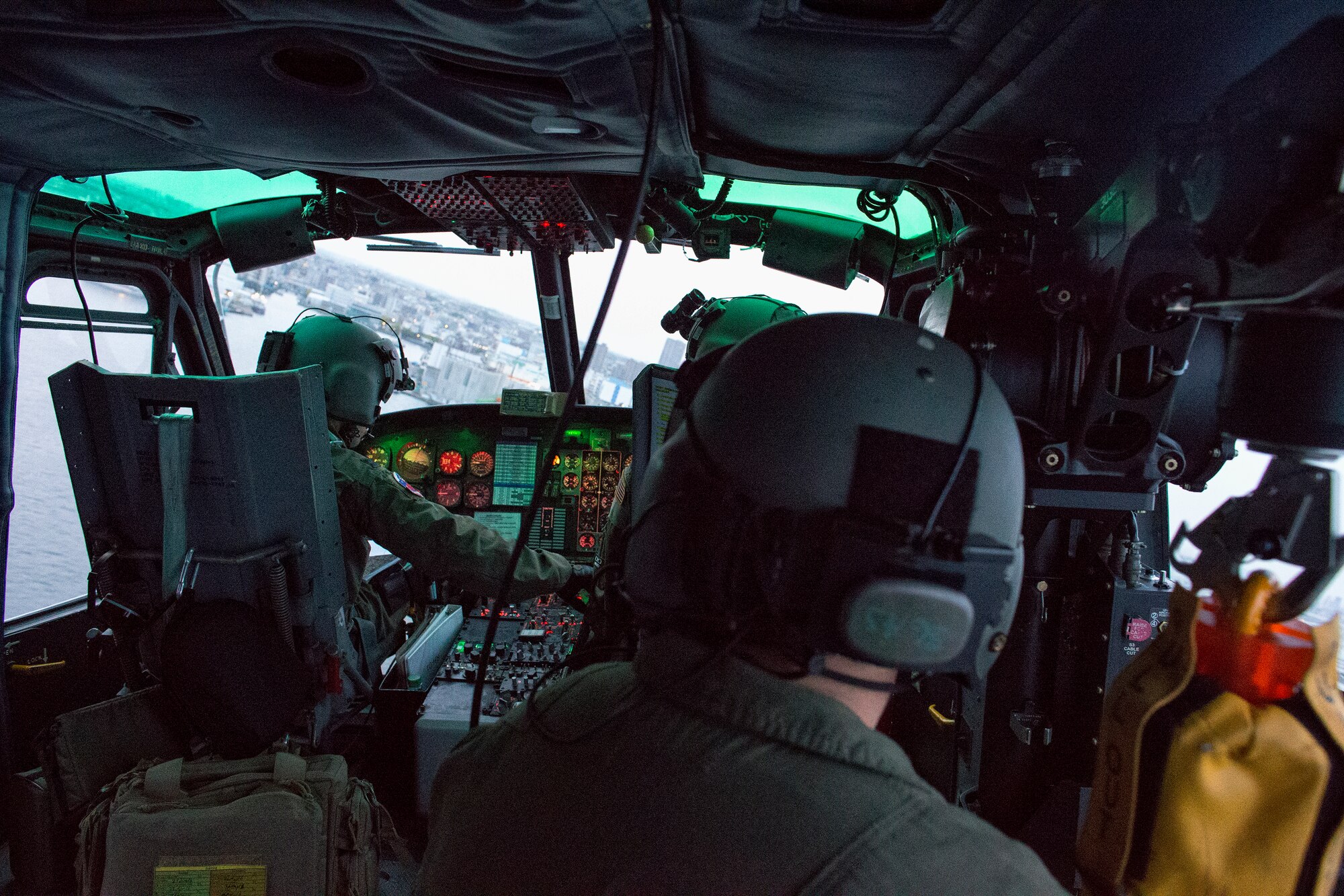 Crewmembers on a UH-1N Iroquois fly over Yokohama bay, April 25, 2016, during a training flight.  Airmen with the 459 AS regularly practice their airlift capabilities in order to respond to regional contingencies. (U.S. Air Force photo by Yasuo Osakabe/Released)