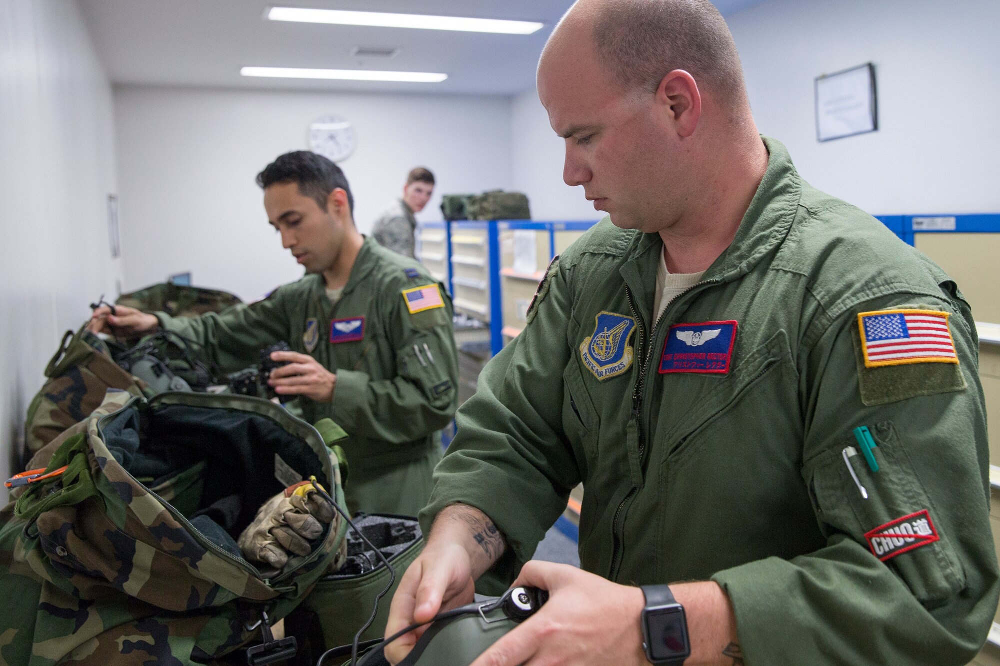 Tech. Sgt. Christopher Rector, right, 459th Airlift Squadron UH-1N special missions aviator evaluator, and Capt. Jonathan Bonilla, left, 459th AS UH-1N pilot, prepare their night vision goggles at Yokota Air Base, Japan, April 25, 2016. The 459 AS regularly conducts training missions to keep their skills proficient. (U.S. Air Force photo by Yasuo Osakabe/Released)