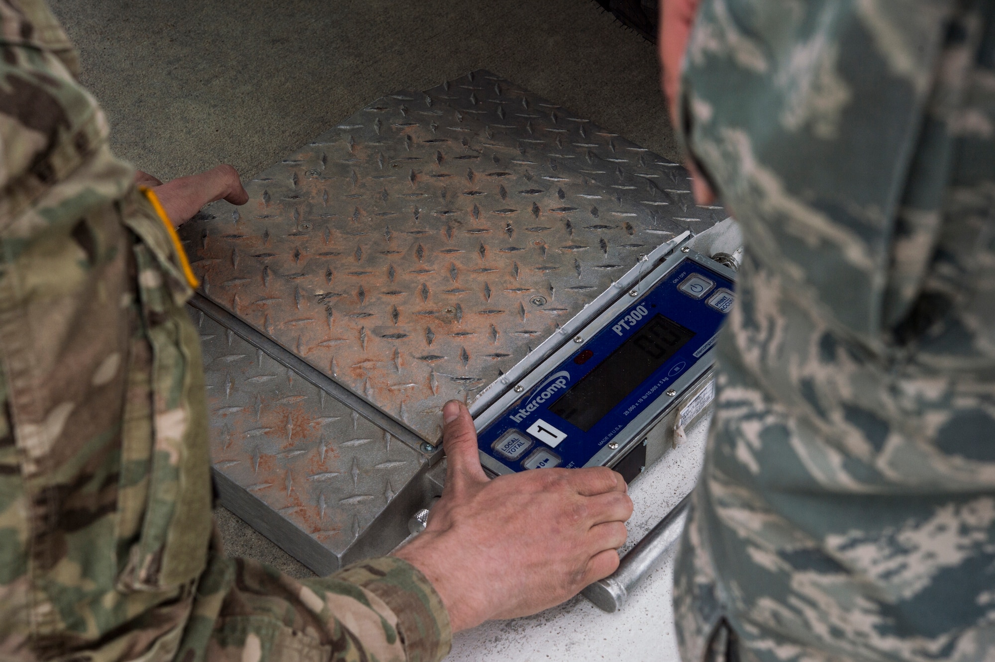 Airmen assigned to the 821st Contingency Response Group at Travis Air Force Base, Calif., and Army Soldiers assigned to the 152d Movement Control Team at Fort Carson, Colo., place a weigh scale on the ground to measure the weight of vehicles as they conduct a joint inspection during Cerberus Strike 16-01 at Fort Carson, Colo., April 23, 2016. The joint exercise is specifically designed for contingency response training across multiple locations in Colorado and Wyoming. (U.S. Air Force photo by Tech. Sgt. Gustavo Gonzalez/Released)