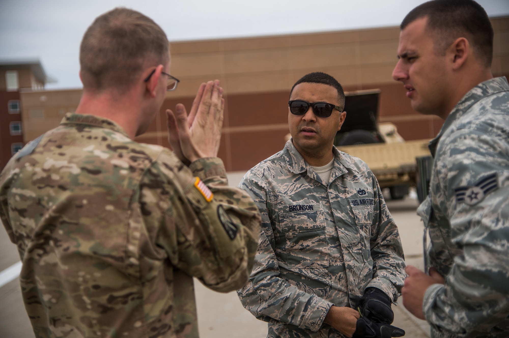 Army Sgt. Bryant Schneegass, 152nd Movement Control Team movement noncommissioned officer stationed at Fort Carson, Colo., talks about conducting a joint inspection on cargo to Air Force Staff Sgt. Erik Brunson and Senior Airman Jake Saville, aerial porters assigned to the 821st Contingency Response Squadron stationed at Travis Air Force Base, Calif., during Cerberus Strike 16-01 at Fort Carson, April 23, 2016. A joint inspection is required of cargo and vehicles that is loaded onto aircraft. (U.S. Air Force photo by Tech. Sgt. Gustavo Gonzalez/Released)