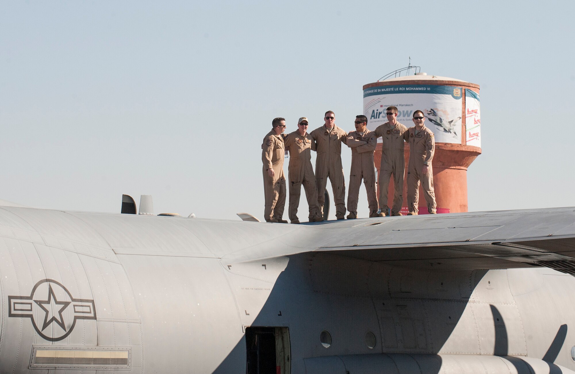 A flight crew from Ramstein Air Base, Germany stand on top of their C-130J Hurcules during the International Marrakech Airshow in Morocco on Apr. 27, 2016. The six-man flight crew are entrusted with transporting the aircraft to the air expo and showcasing the aircrafts capabilities for spectators. (DoD News photo by TSgt Brian Kimball)