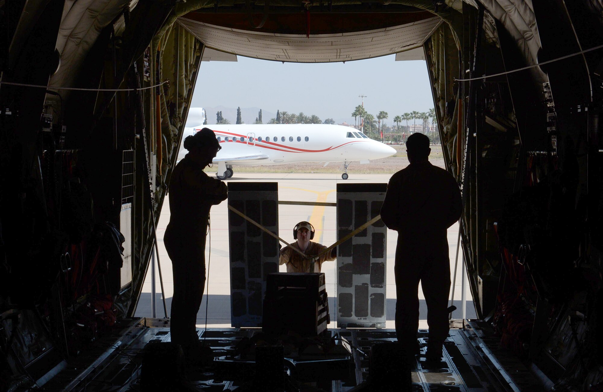 Aircrew from the 37th Airlift Squadron and 86th Aircraft Maintenance Squadron stand on the rear cargo bay of a C-130J Hercules after landing on the flight line in Marrakech, Morocco on Apr. 26, 2016. The six-man flight crew is entrusted with transporting the aircraft to the 2016 International Marrakech Airshow in Morocco and showcasing the aircrafts capabilities. (DoD News photo by TSgt Brian Kimball)