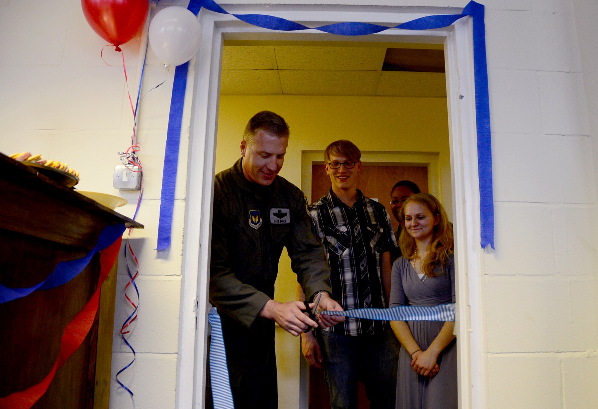 Col. David Eaglin, 48th Fighter Wing vice commander, takes part in a ribbon-cutting ceremony to mark the opening of the new Airman Community Center at Royal Air Force Lakenheath, England, April 22. Airmen dedicated countless hours toward opening the facility in hopes to provide a place for dorm residents to socialize and meet other Airmen. (U.S. Air Force photo/Senior Airman Erin Trower) 