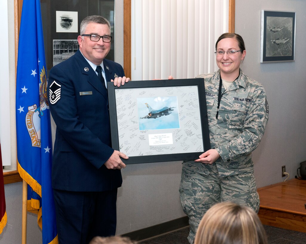Master Sgt. Thomas Worrell had a retirement ceremony in the 132d Wing Classroom. Tech. Sgt. Alisha Seeley presented a retirement gift to him. (U.S. Air National Guard photo by Tech. Sgt. Michael B. McGhee/Released)