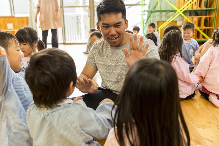 Petty Officer 3rd Class Antonio Medelgonzal, a harbor operations dispatcher with Headquarters and Headquarters Squadron on Marine Corps Air Station Iwakuni, high-fives children at Josho Hoikuen School in Iwakuni City, Japan, April 19, 2016. Visiting the school provided service members the chance to teach children how to speak and count in English, fostering the friendship between the U.S. and Japan. The visit afforded the children the opportunity to meet and interact with new people. (U.S. Marine Corps photo by Lance Cpl. Aaron Henson/Released)