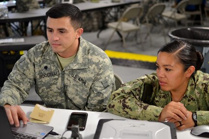 A Soldier and member of the U.S. Navy work on communication processes while setting up for exercise Anakonda Response 2016 on Papa Air Base, Hungary, April 27, 2016. This exercise will be implementing the Perspective Integration method during the mission, which requires mission planners to account for cultural factors in how gender roles affect men, women, boys and girls differently in a disaster. (U.S. Air National Guard photo by Tech. Sgt. Andria Allmond)