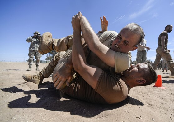 A U.S. Airman and a Royal Netherlands Army soldier wrestle after receiving a level two exposure to pepper spray as part of a nonlethal weapons class during exercise African Lion 16 in Tifnit, Morocco, April 23, 2016. The participants of the class had the opportunity to receive either a level one or two exposure before practicing nonlethal skills learned during the class. (U.S. Air Force photo/Senior Airman Krystal Ardrey)