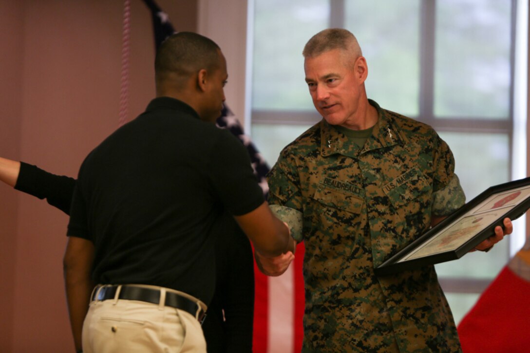 Major Gen. Brian Beaudreault, commanding general of 2nd Marine Division, commemorates Staff Sgt. Terrance Shorty, the career planner for 3rd Battalion, 6th Marine Regiment, for his hard work and dedication to volunteering with the Marines in his unit, during a ceremony held at Camp Lejeune, N. C., April 27, 2016. The 2nd Marine Division honored numerous Marines from all around its units for giving their time back to the community. (U.S. Marine Corps photo by Cpl. Melodie Snarr/Released)