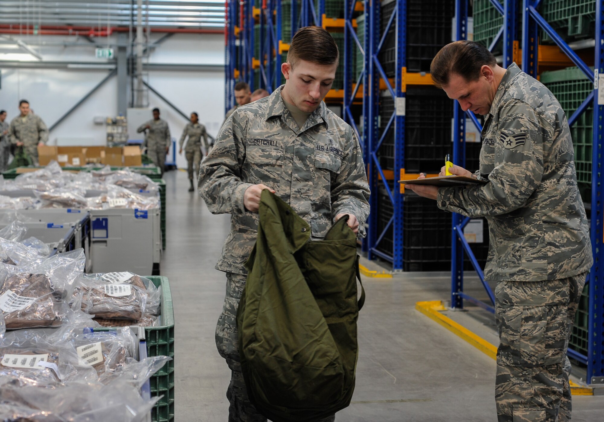 Airman 1st Class Benjamin Gotchall, 86th Aerospace Medicine Squadron public health technician has his individual protective equipment checked by Senior Airman Christopher Clark, 445th Air Reserve Base Logistics Readiness Squadron supply technician at Wright-Patterson Air Force Base, Ohio, on April 20, at Ramstein Air Base, Germany. Gotchall was a part of a group of 25 medical personnel tasked to go through the LRS IPE issue line during exercise Wing Thunder. (U.S. Air Force photo/Staff Sgt. Leslie Keopka)