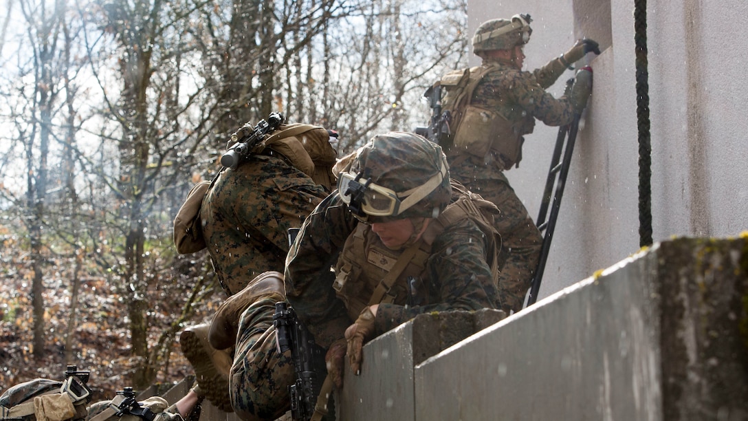 U.S. Marine Corps Lance Cpl. Craig Finnerty, a mortarman with Special Purpose Marine Air-Ground Task Force-Crisis Response-Africa, maintains a low profile as he maneuvers over a wall during a stress event held by U.S. Army Special Forces in Germany, Apr. 12, 2016. The stress event consisted of a timed firing course, an urban agility course and a squad log run to test the Marines’ speed and endurance under stressful conditions. 