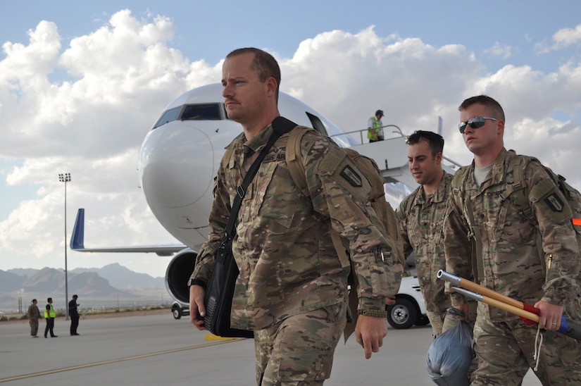 Soldiers assigned to the 716th Eng. Co. walk the tarmac toward the Silas L. Copeland Arrival/Departure Airfield Control Group after arriving stateside April 18.