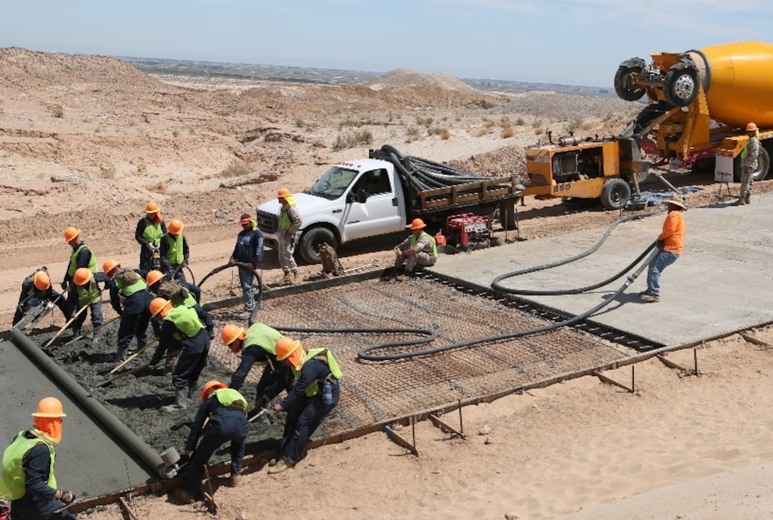 U.S. Marines with 7th Engineer Support Battalion assist in pouring out concrete during a road improvement project with Joint Task Force North in El Centro, Calif., April 19, 2016. For the last two months, the Marines have been processing and leveling dirt to improve the road’s quality as well as constructing low-water crossings to maintain the integrity of the road during wet conditions. (U.S. Marine Corps photo by Cpl. Carson Gramley/released)