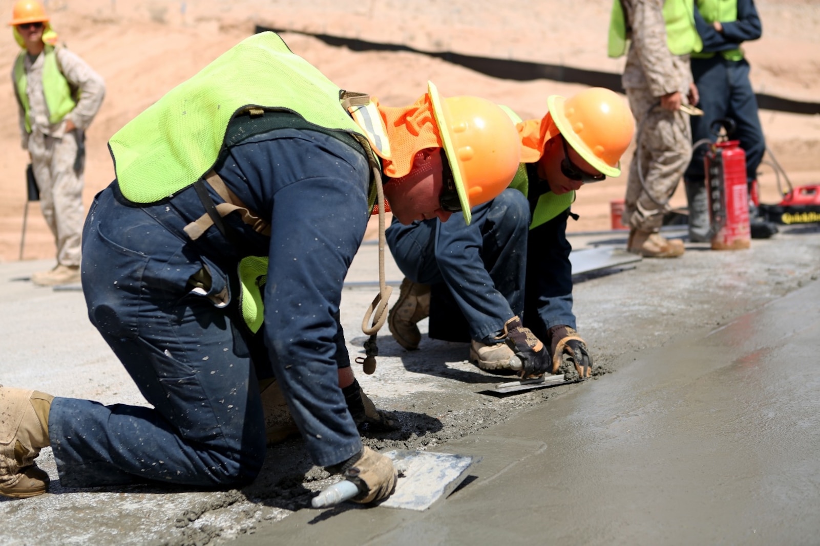 U.S. Marine Corporals Cody Moore and James Stroeher use concrete edgers to refine the edge of a concrete slab during a road improvement project with Joint Task Force North in El Centro, Calif., April 19, 2016. Moore and Stroeher are with 7th Engineer Support Battalion, Bridge Company. For the last two months, the Marines have been processing and leveling dirt to improve the road’s quality as well as constructing low-water crossings to maintain the integrity of the road during wet conditions. (U.S. Marine Corps photo by Cpl. Carson Gramley/released)