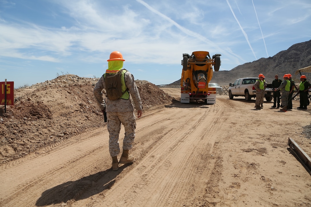 U.S. Marine Staff Sgt. Carlos Rodriguez guides a concrete truck backward during a road improvement project with Joint Task Force North in El Centro, Calif., April 19, 2016. Rodriguez is the staff non-commissioned officer in charge of Headquarters and Support Company, 7th Engineer Support Battalion. For the last two months, the Marines have been processing and leveling dirt to improve the road’s quality as well as constructing low-water crossings to maintain the integrity of the road during wet conditions. (U.S. Marine Corps photo by Cpl. Carson Gramley/released)