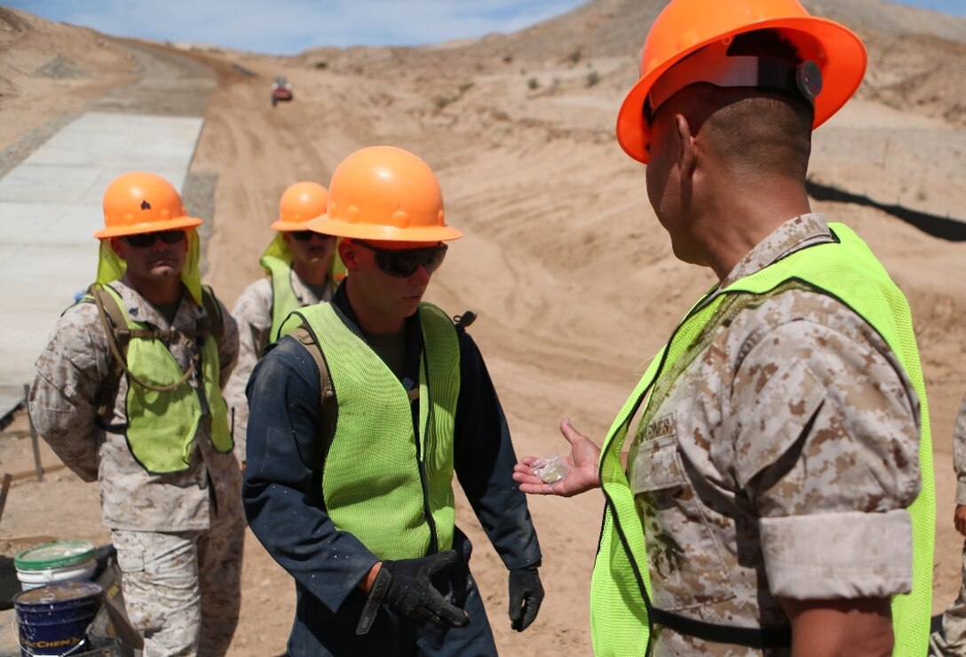U.S. Marine Col. Ladaniel Dayzie presents a Marine from 7th Engineer Support Battalion with a challenge coin in El Centro, Calif., April 19, 2016. Dayzie is the deputy commander of Joint Task Force North in El Centro. Marines with 7th ESB assisted in a road improvement project with JTF-N during the months of March and April. During the project, the Marines have been processing and leveling dirt to improve the road’s quality as well as constructing low-water crossings to maintain the integrity of the road during wet conditions. (U.S. Marine Corps photo by Cpl. Carson Gramley/released)