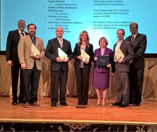 FLC State and Local Economic Development Award winners, left to right:  Paul Zielinski, NIST/FLC Chair; Norman Hedges, IU Law Clinic; Cliff Wojtalewicz, Purdue University; Brooke Pyne, NSWC Crane ORTA/T2 Program Manager; Dottie Vincent, ONR T2 Director; John Dement, IODD; and Mark Reeves, Oak Ridge National Lab/FLC Vice-Chair