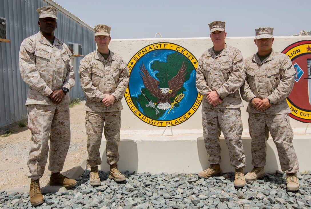 U.S. Marine Corps Sgt. Maj. Reginald Robinson and Col. William Mccollough, left, the former sergeant major and commanding officer of the Special Purpose Marine Air-Ground Task Force Crisis Response-Central Command (SPMAGTF-CR-CC), pose for a photo with Col. Kenneth Kassner and Sgt. Maj. Chuong Nguyen, the commanding officer and sergeant major the incoming SPMAGTF-CR-CC, in an undisclosed location, Southwest Asia, April 23, 2016. (U.S. Marine Corps photo by Cpl. Trever A. Statz/Released)