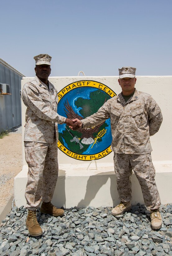 U.S. Marine Corps Sgt. Maj. Reginald Robinson, left, the former sergeant major of the Special Purpose Marine Air-Ground Task Force Crisis Response-Central Command (SPMAGTF-CR-CC), shakes hands with Sgt. Maj. Chuong Nguyen, the sergeant major of the incoming SPMAGTF-CR-CC, in an undisclosed location, Southwest Asia, April 23, 2016. (U.S. Marine Corps photo by Cpl. Trever A. Statz/Released)
