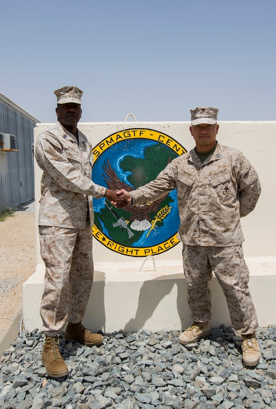 U.S. Marine Corps Sgt. Maj. Reginald Robinson, left, the former sergeant major of the Special Purpose Marine Air-Ground Task Force Crisis Response-Central Command (SPMAGTF-CR-CC), shakes hands with Sgt. Maj. Chuong Nguyen, the sergeant major of the incoming SPMAGTF-CR-CC, in an undisclosed location, Southwest Asia, April 23, 2016. (U.S. Marine Corps photo by Cpl. Trever A. Statz/Released)