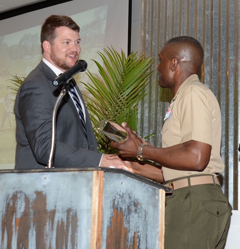 Col. James C. Carroll III, commanding officer, Marine Corps Logistics Base Albany, accepts the 2016 Only One Albany Industry Award from Justin Strickland, president and CEO, Albany-Dougherty Economic Development Commission, Albany, Ga., during a special Rise-n-Shine breakfast honoring local industries and hosted by the Albany Area Chamber of Commerce, recently. “MCLB Albany has a long and storied history of being an important community partner and continues to embody the Three C’s of the United States Marine Corps—community, country and Corps,” Strickland said. 