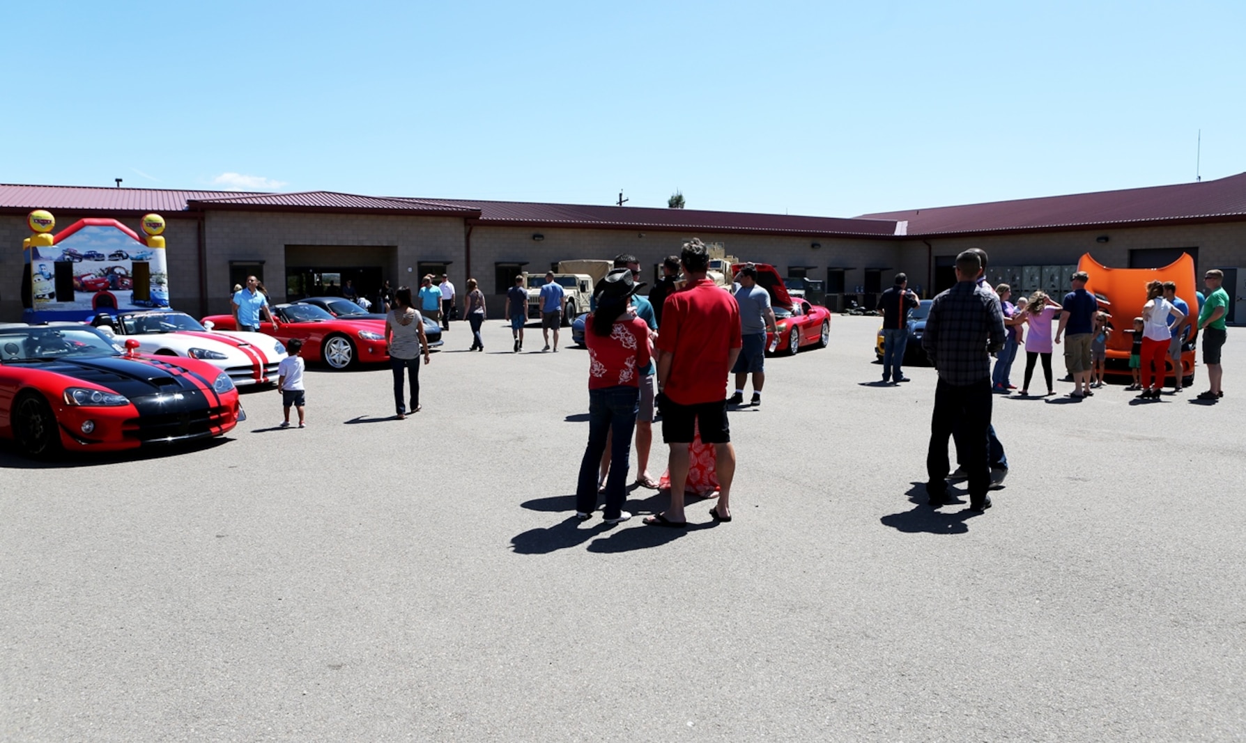 Marines and their families look at a line-up of show cars during a family day hosted by 1st Explosive Ordnance Disposal Company, 7th Engineer Support Battalion, 1st Marine Logistics Group, aboard Camp Pendleton, Calif., April 23, 2016. Marines with 1st EOD Co. hosted the Viper Club of Southern California for the day as a part of their celebration which included food, family activities, and various show cars. (U.S. Marine Corps photo by Cpl. Carson Gramley/released)