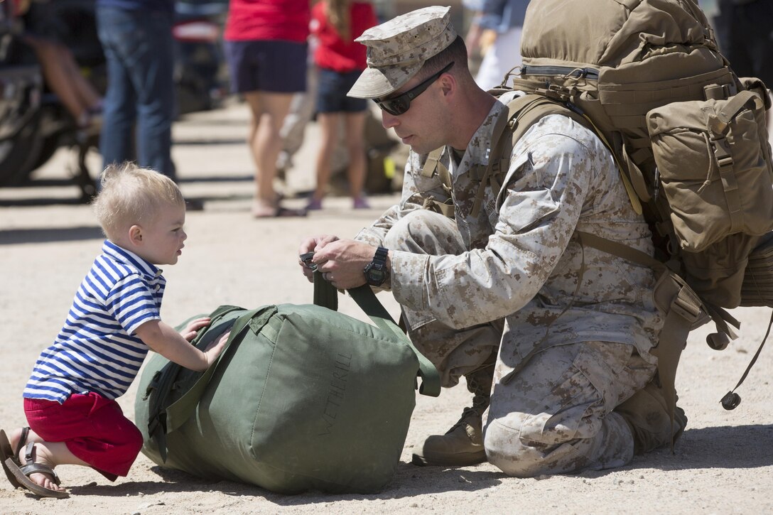 Barret, 2, son of Capt. Sean Wetherill, logistics officer, 1st Battalion, 7th Marine Regiment, helps his father gather his belongings during the battalion’s homecoming at Del Valle Field April 23, 2016. 1/7 was deployed as part of Special Purpose Marine Air Ground Task Force-Crisis Response-Central Command 16.1. (Official Marine Corps photo by Cpl. Julio McGraw/Released)