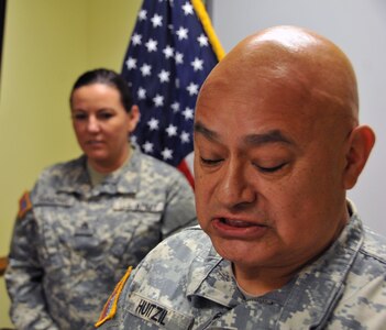 Chief Warrant Officer 3  Jorge Huitzil, assigned to the U.S. Army Reserve's 99th Regional Support Command at Joint Base McGuire-Dix-Lakehurst, New Jersey, reads a citation for Staff Sgt. Heather Simmons.  Simmons received her appointment as a Warrant Officer Candidate April 29.