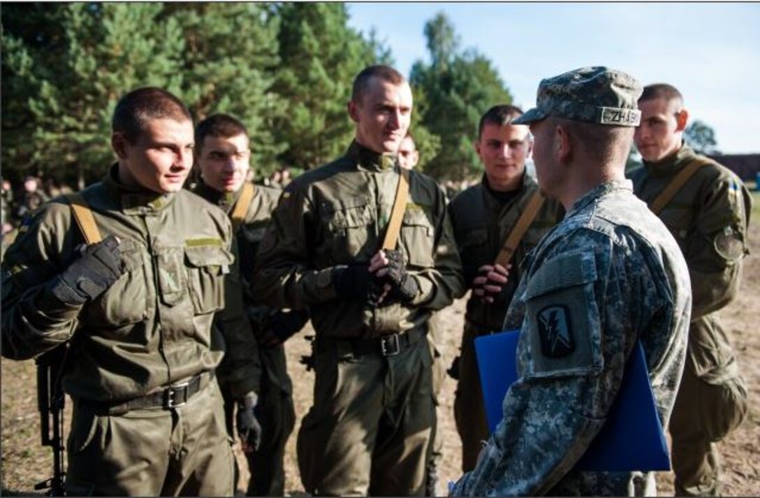 U.S. Army Spc. Zhabka Aleksey, a California National Guard Soldier from the 223rd Military Intelligence Battalion talks to a group of Ukrainian National Guard Soldiers during situational training exercise lanes at Exercise Rapid Trident in 2014 in Yavoriv, Ukraine. Rapid Trident is an annual U.S. Army Europe conducted, Ukrainian led, multinational exercise designed to enhance interoperability with allied and partner nations while promoting regional stability and security