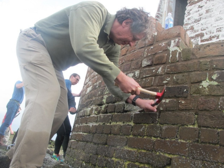 Ed Krolikowski, deputy to the chief of Engineering Division, U.S. Army Corps of Engineers, Savannah District, removes old mortar from the exterior of the Cockspur Island Lighthouse, April 1. Krolikowski, along with volunteers from the local chapter of the American Institute of Architects (AIA Savannah), and students from the Savannah College of Art and Design, assisted Fort Pulaski National Monument staff in restoring the lighthouse.