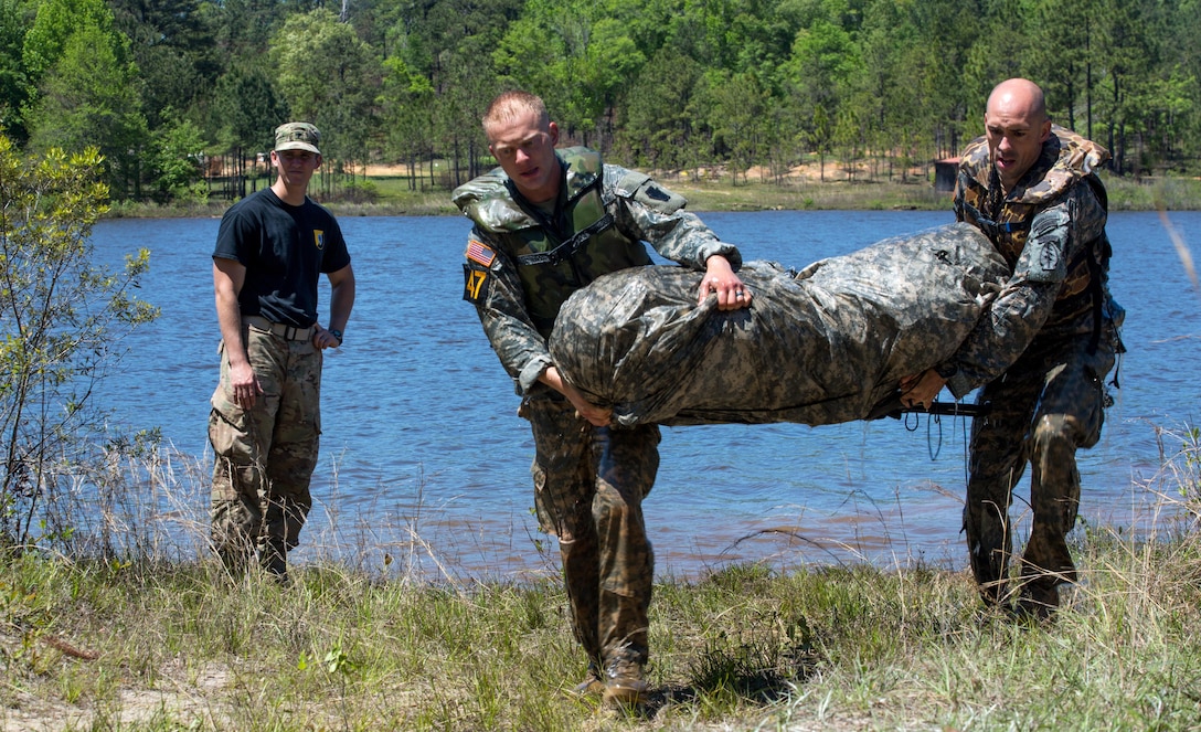 Army Capt. Robert Killian and Army Staff Sgt. Erich Friedlein carry gear to the next obstacle during the Best Ranger Competition 2016 at Fort Benning, Ga., April 17, 2016. Killian and Friedlein are assigned to the National Guard. Army photo by Spc. Steven Hitchcock
