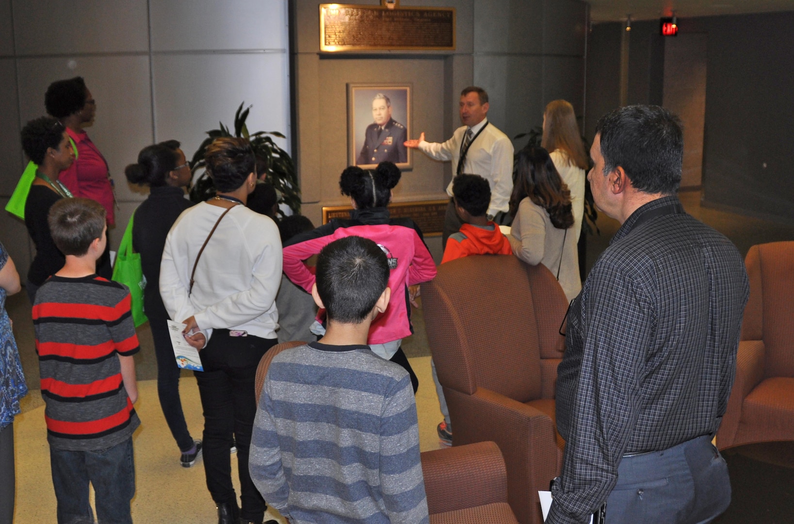 Leading a tour of the McNamara Headquarters Complex, Mark Simon shows kids and parents a portrait of  Lt. Gen. Andrew T. McNamara, first director of the Defense Logistics Agency, during 'Take You Daughters and Sons to Work Day' April 28.