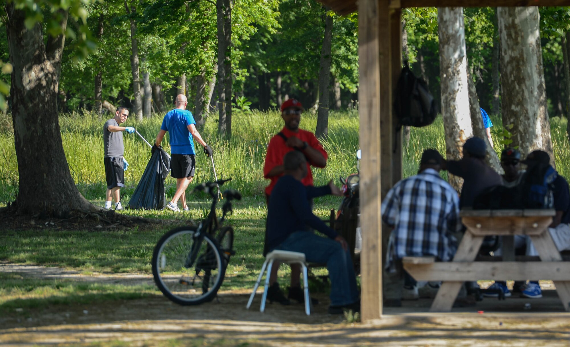 U.S. Airmen pick up trash at a park in Sumter, S.C., April 29, 2016. Team Shaw Airmen spent several hours picking trash up in Sumter parks and beautifying Swan Lake and Iris Gardens an effort to improve to quality of life for all residents. (U.S. Air Force photo by Senior Airman Jensen Stidham)