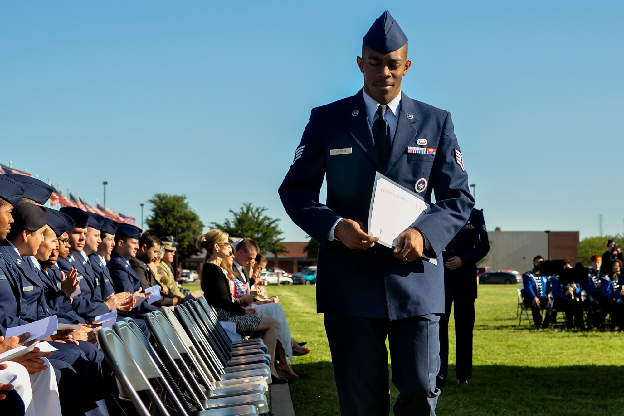 U.S. Air Force Tech. Sgt. Terrence Arthur, 316th Training Squadron instructor, walks back to his seat after receiving his Community College of the Air Force certificate of completion at the parade field on Goodfellow Air Force Base, Texas, April 27, 2016. Arthur was one of 151 enlisted members from Goodfellow who graduated. (U.S. Air Force photo by 2nd Lt. Tisha Wilkerson/Released)
