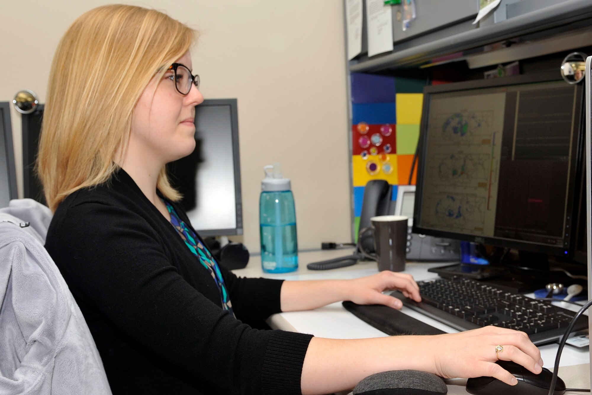 Samantha Strong-Henninger, meteorologist for the 557th weather wing, compares images for a dust study on Offutt Air Force Base, Neb., April 28, 2016. (U.S. Air Force photo by Jeff W. Gates)