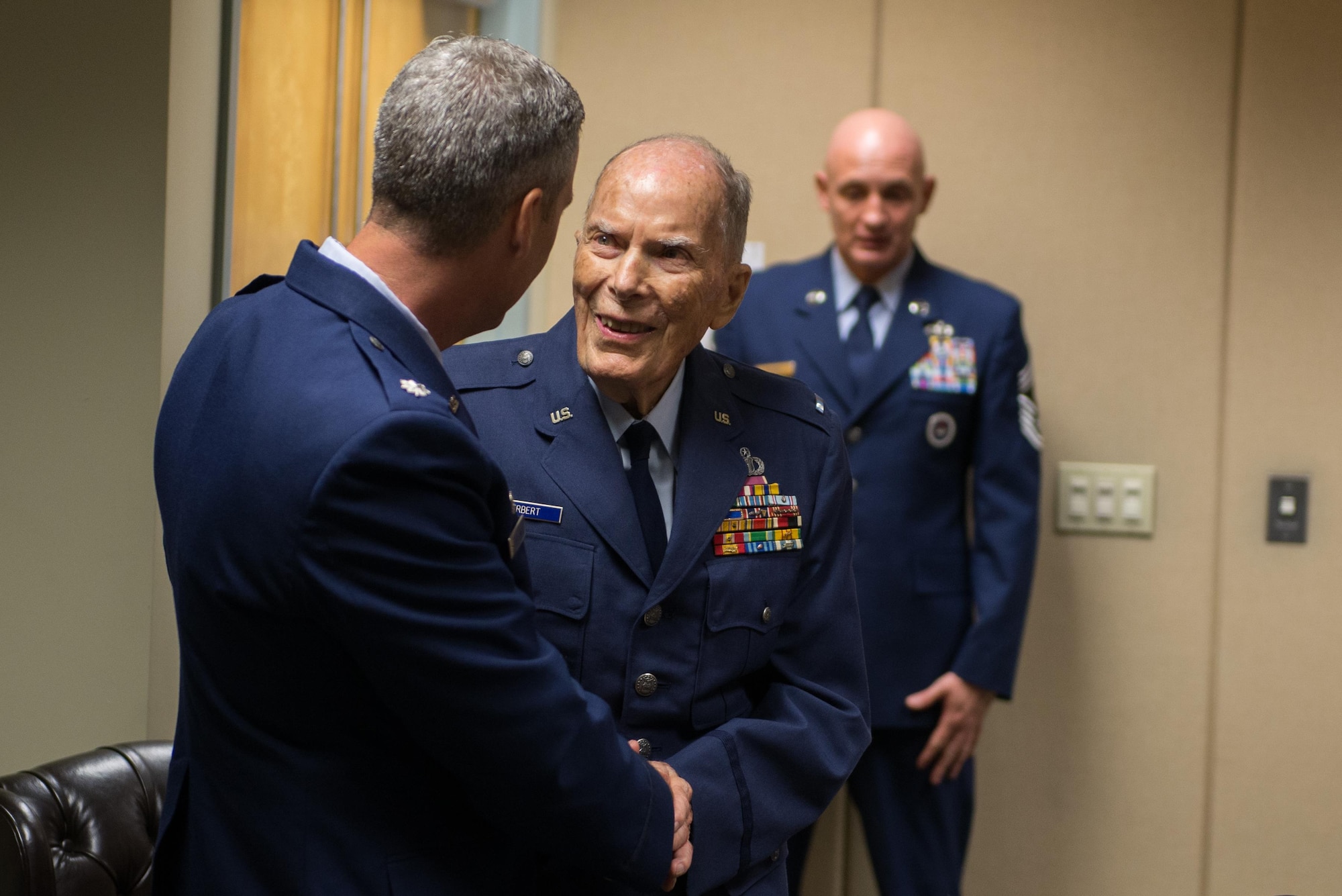 Retired Chief Warrant Officer 4 Francis Herbert is welcomed by Lt. Col. Steven Mullins, 334th Training Squadron commander, during a room dedication ceremony in Cody Hall April 26, 2016, Keesler Air Force Base, Miss. The room was dedicated to Herbert for his 50 years of service in air traffic control in the Army, Army Air Corps, and Air Force from 1942-1972, then as a Keesler civilian instructor for 20 years. (U.S. Air Force photo by Marie Floyd)