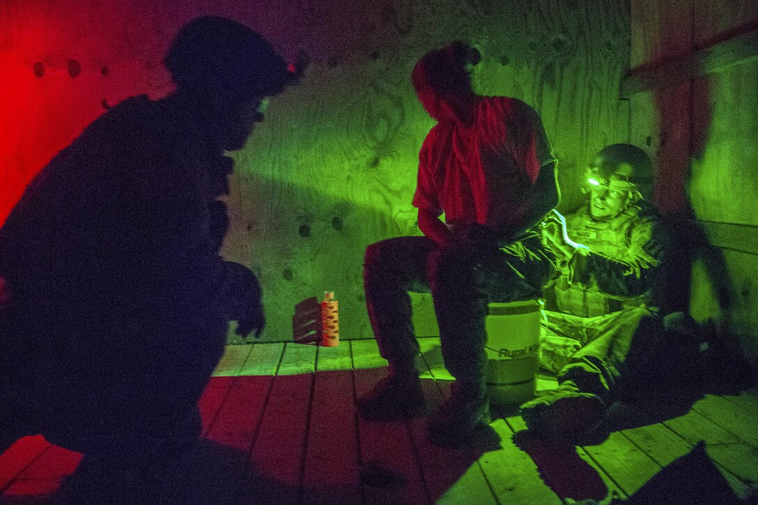 Army Spc. Jason Green, left, talks to a hostage role player while Staff Sgt. Jesse Harris works to disarm explosives during a hostage rescue scenario for the 52nd and 111th Ordnance Group Joint Team of the Year 2016 competition at a training center in Greenville, Ky., April 28, 2016. The weeklong event tests teams in various scenarios they may encounter in situations around the world. Green is assigned to the 49th Ordnance Company, 184th Ordnance Battalion. Army Photo by Staff Sgt. Brian Kohl