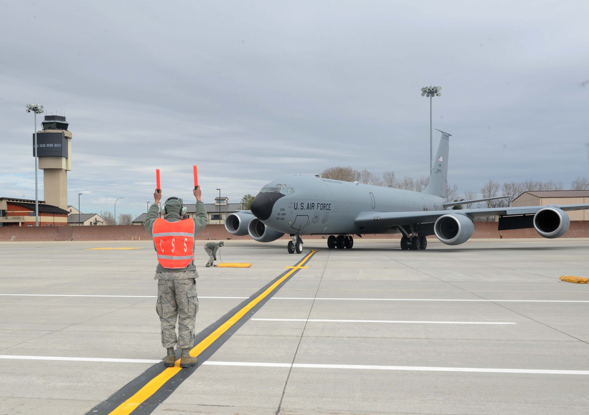 A 22nd Aircraft Maintenance Squadron crew chief marshals one of McConnell’s KC-135 Stratotanker, April 26, 2016, at Grand Forks Air Force Base, N.D. A total of 19 aircraft were evacuated from McConnell to keep them safe from incoming inclement weather. (U.S. Air Force photo by Senior Airman Tara Fadenrecht)