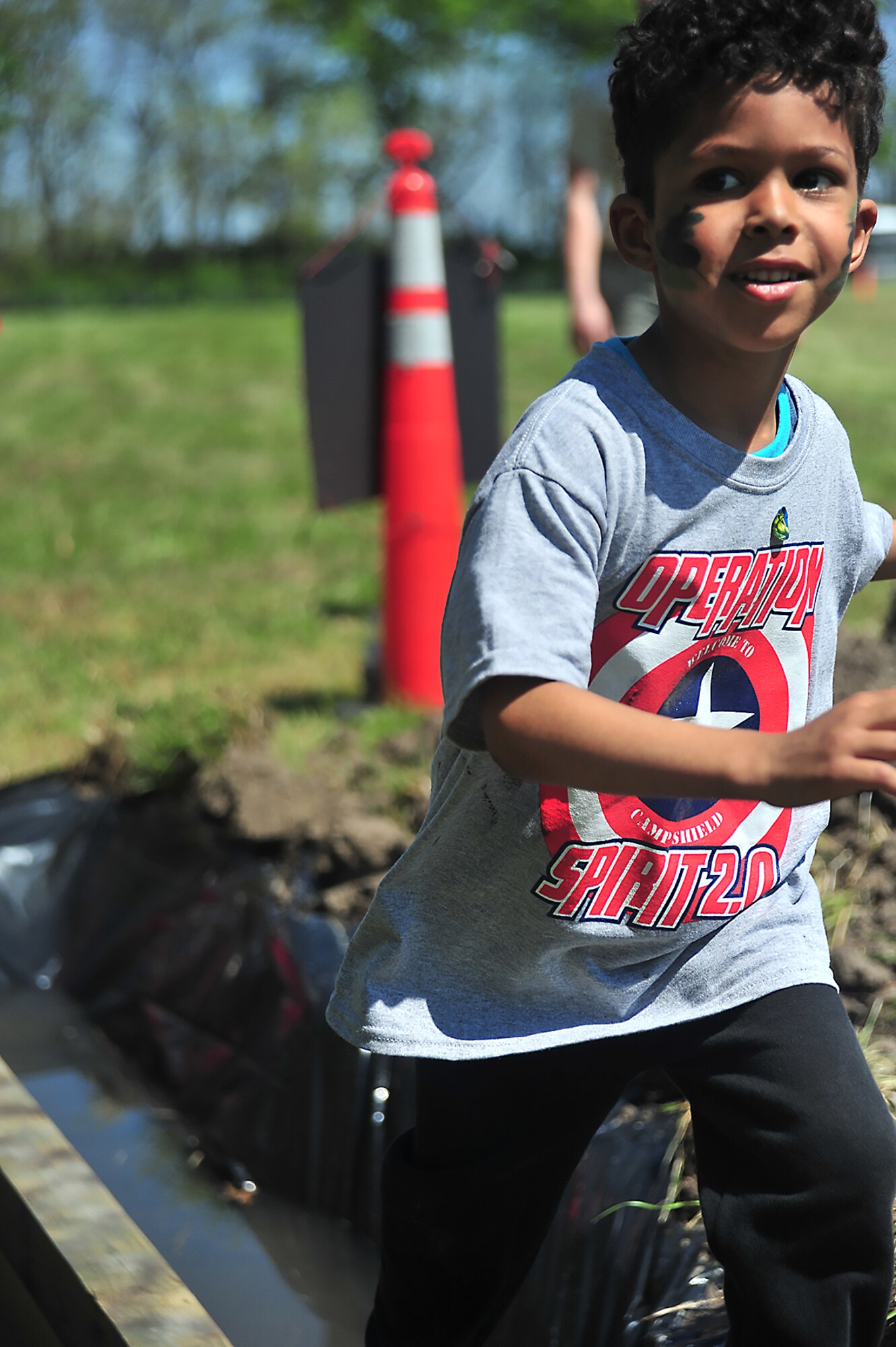 Christian Johnson, son of U.S. Air Force Tech. Sgt. Shauna Robinson, the 509th Comptroller Squadron NCO in charge of financial management, smiles as he finishes part of Operation Spirit’s obstacle course at Whiteman Air Force Base, Mo., April 23, 2016. Participants in Operation Spirit had the chance to experience elements of Air Force deployments. (U.S. Air Force photo by Senior Airman Jovan Banks)