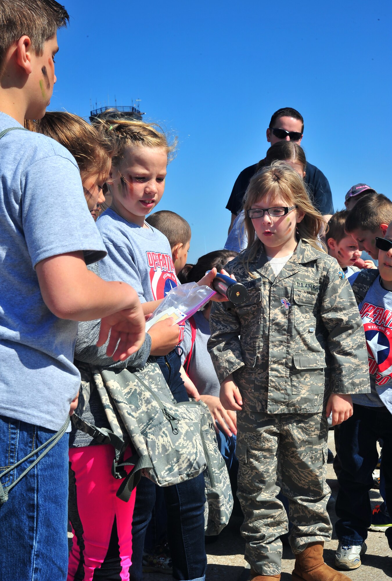 Team Whiteman youths pass around an A-10 Thunderbolt II munition display during Operation Spirit at Whiteman Air Force Base, Mo., April 23, 2016. Participants of the event were informed of the capabilities and missions of the A-10, B-2 Spirit and T-38 Talon aircraft. (U.S. Air Force photo by Senior Airman Jovan Banks)