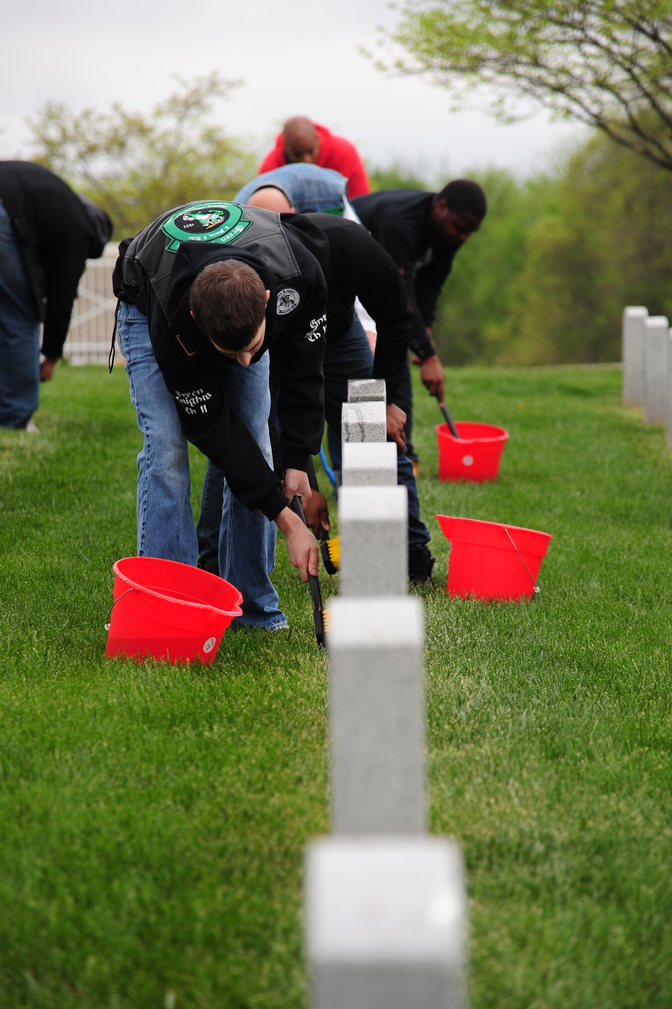 Participants in Motorcycle Safety Day clean headstones at the Missouri Veterans Cemetery in Higginsville, Mo., April 25, 2016. Participants closed Motorcycle Safety Day by taking part in a mentorship ride to the cemetery and volunteering to clean the grounds. (U.S. Air Force photo by Senior Airman Joel Pfiester)