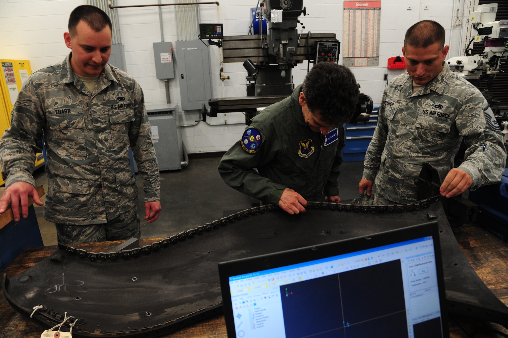 U.S. Air Force Senior Airman Matthew Ebarb, a 509th Maintenance Squadron aircraft metals technician, left, Dean Kamen, the FIRST Robotics founder, center, and Master Sgt. Chad Tanner, the NCO in charge of Air Force recruiting services event marketing, examine a part of the B-2 exhaust system at Whiteman Air Force Base, Mo., April 26, 2016. Kamen met Airmen and FIRST Robotics alumni during his visit and received an incentive flight in a B-2 Spirit. The U.S. Air Force and FIRST Robotics share an interest in developing youth into future leaders through exposure to education in science, technology, engineering and mathematics. (U.S. Air Force photo by Airman 1st Class Keenan Berry)