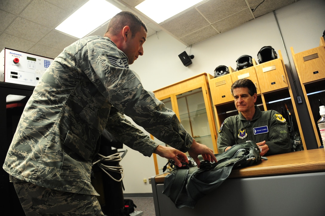 U.S. Air Force Tech. Sgt. Joshua Riffe, a 509th Operation Support Squadron aircrew flight equipment supervisor, left, explains features on a PCU-15/P torso harness to Dean Kamen, the FIRST Robotics founder, at Whiteman Air Force Base, Mo., April 26, 2016. Kamen met Airmen and FIRST Robotics alumni during his visit and received an incentive flight in a B-2 Spirit. The U.S. Air Force and FIRST Robotics share an interest in developing youth into future leaders through exposure to education in science, technology, engineering and mathematics. (U.S. Air Force photo by Airman 1st Class Keenan Berry)