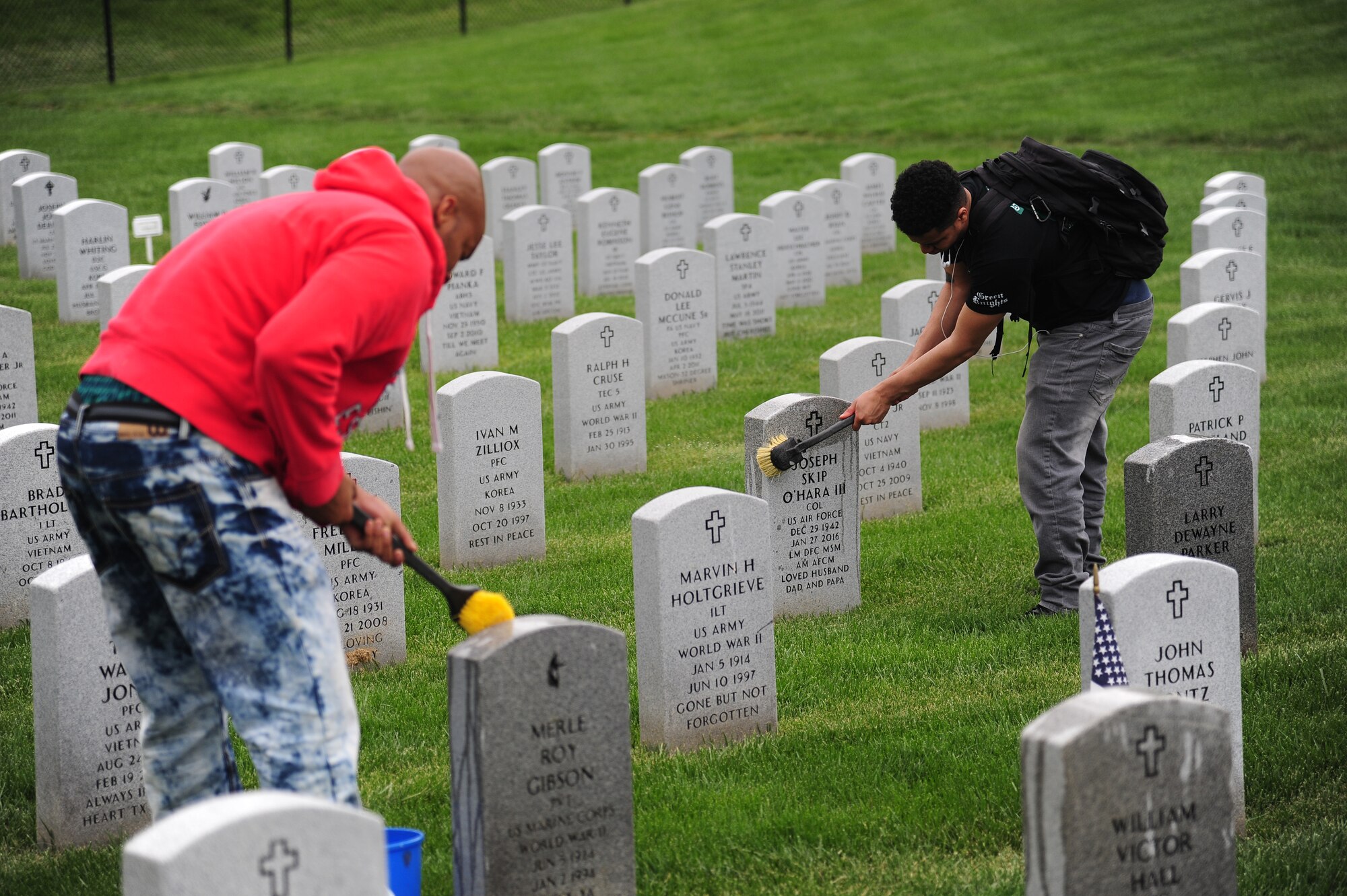 Participants in Motorcycle Safety Day clean headstones at the Missouri Veterans Cemetery in Higginsville, Mo., April 25, 2016. As part of Motorcycle Safety Day, volunteers join together in a mentorship ride to the cemetery to help clean the cemetery grounds. (U.S. Air Force photo by Senior Airman Joel Pfiester)