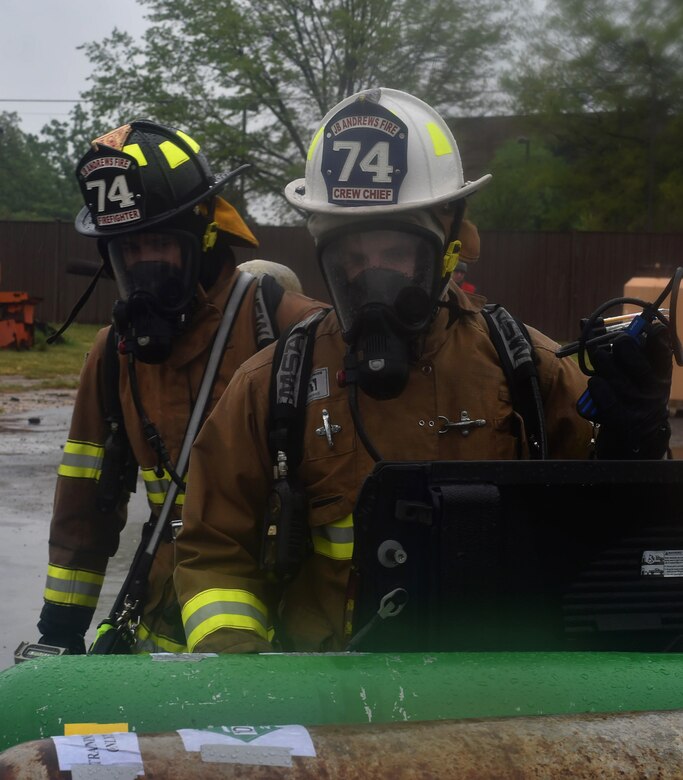 Airman 1st Class Alvaro Munarriz, 11th Civil Engineer Squadron firefighter, left, and Staff Sgt. Clinton Oliver, 11th CES crew chief, perform their initial sweep of the affected area during a Chemical, Biological, Radiological, Nuclear and Explosives training exercise at Joint Base Andrews, Md., April 28, 2016. The scenario simulated a disgruntled Airman that released ammonia on base to cause mass casualties in the contamination area. (U.S. Air Force photo by Senior Airman Dylan Nuckolls/Released)